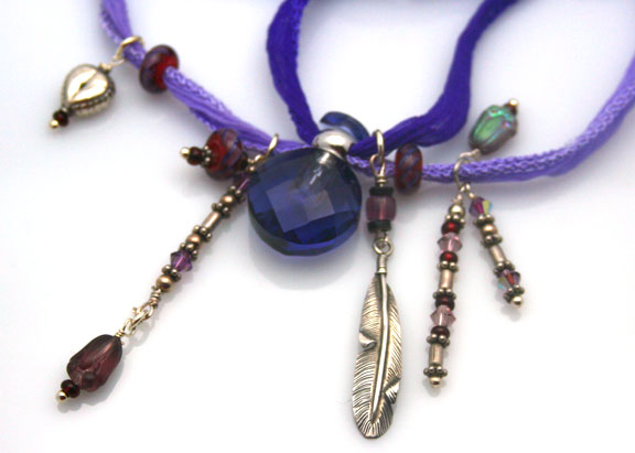 close-up photo of the mini, glass, faceted essential oil bottle and the charms