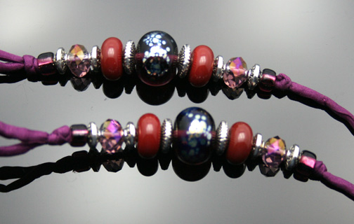 close-up photo of the red and plum custom glass beads