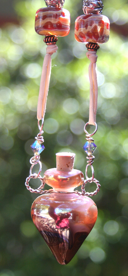 aromatherapy jewelry hanging in the sun to show off the vibrant qualities of the lampwork glass