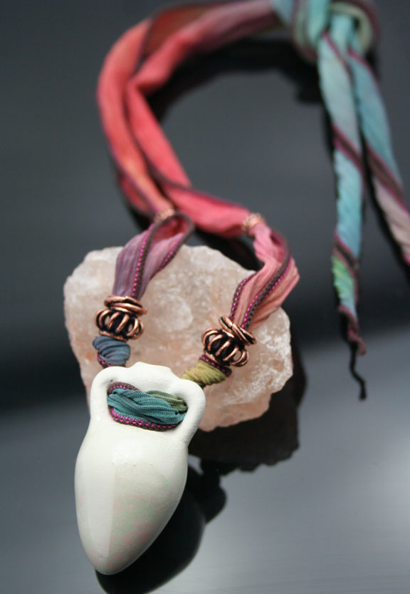 close-up of the amphora, the copper beads, and the hand-painted silk ribbon