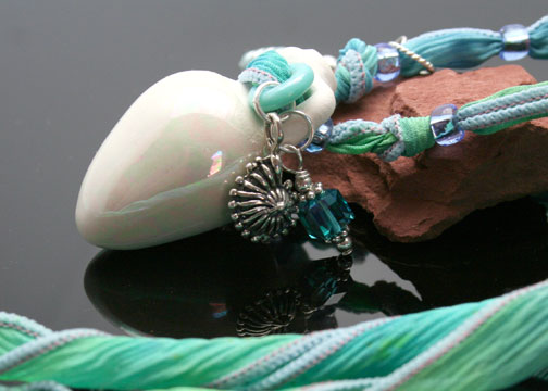 Swarovski crystal dangles and sterling silver beach charms adorn this pretty aromatherapy necklace