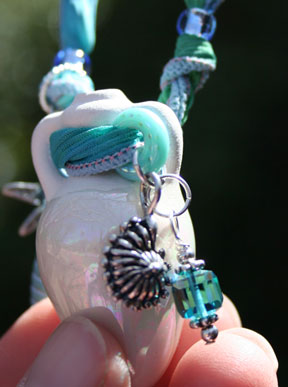 close up phoro of silver charms, crystal glass dangle and quality findings